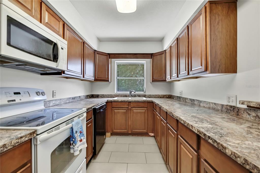 12130 Maple Street Dunnellon, FL 34432 - Photo 8 of 54 a kitchen with stainless steel appliances granite countertop a sink stove and microwave