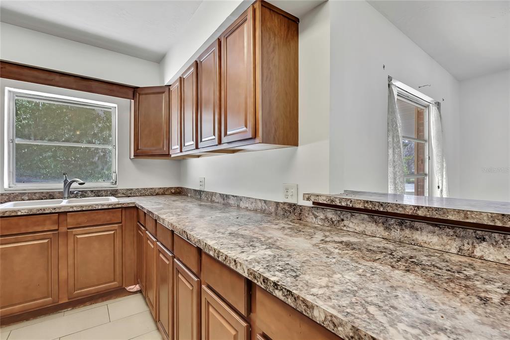 12130 Maple Street Dunnellon, FL 34432 - Photo 10 of 54 a kitchen with granite countertop sink cabinets and window