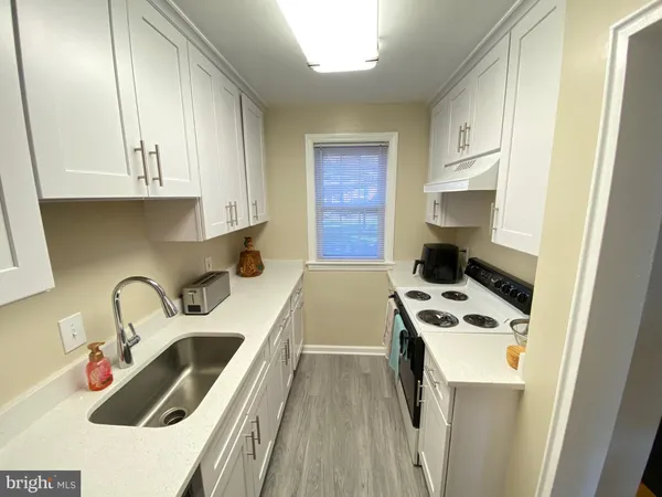 a kitchen with a sink a stove and cabinets