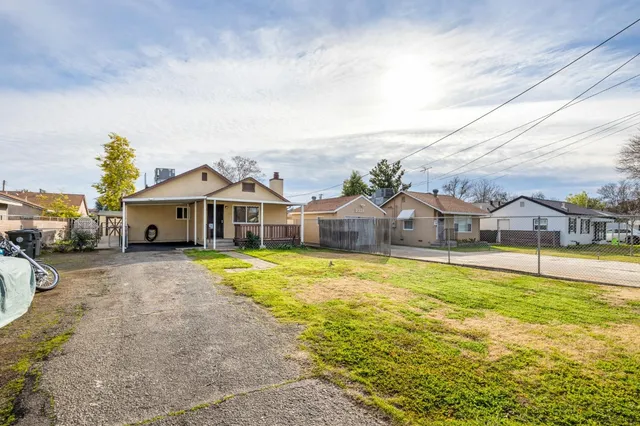 a front view of a house with a big yard and large trees