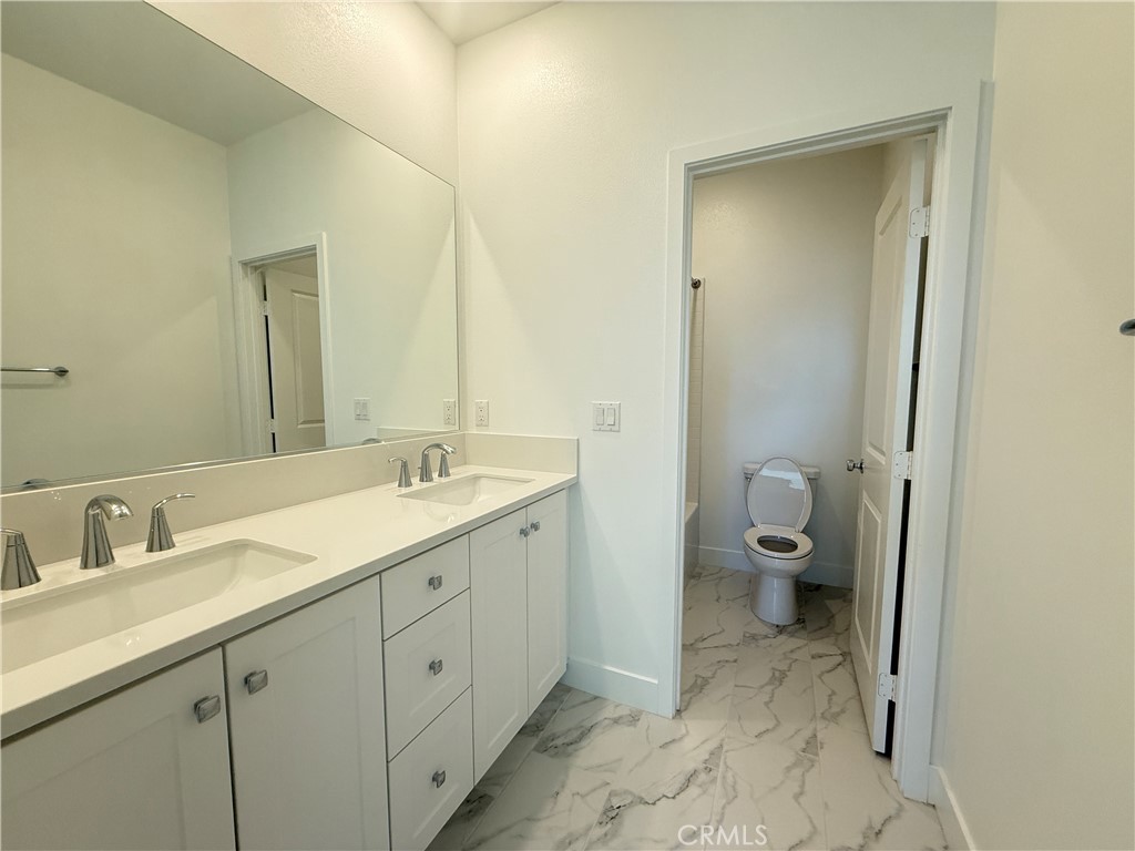 313 Proctor Irvine, CA 92618 - Photo 16 of 24 a spacious bathroom with a double vanity sink toilet and a mirror