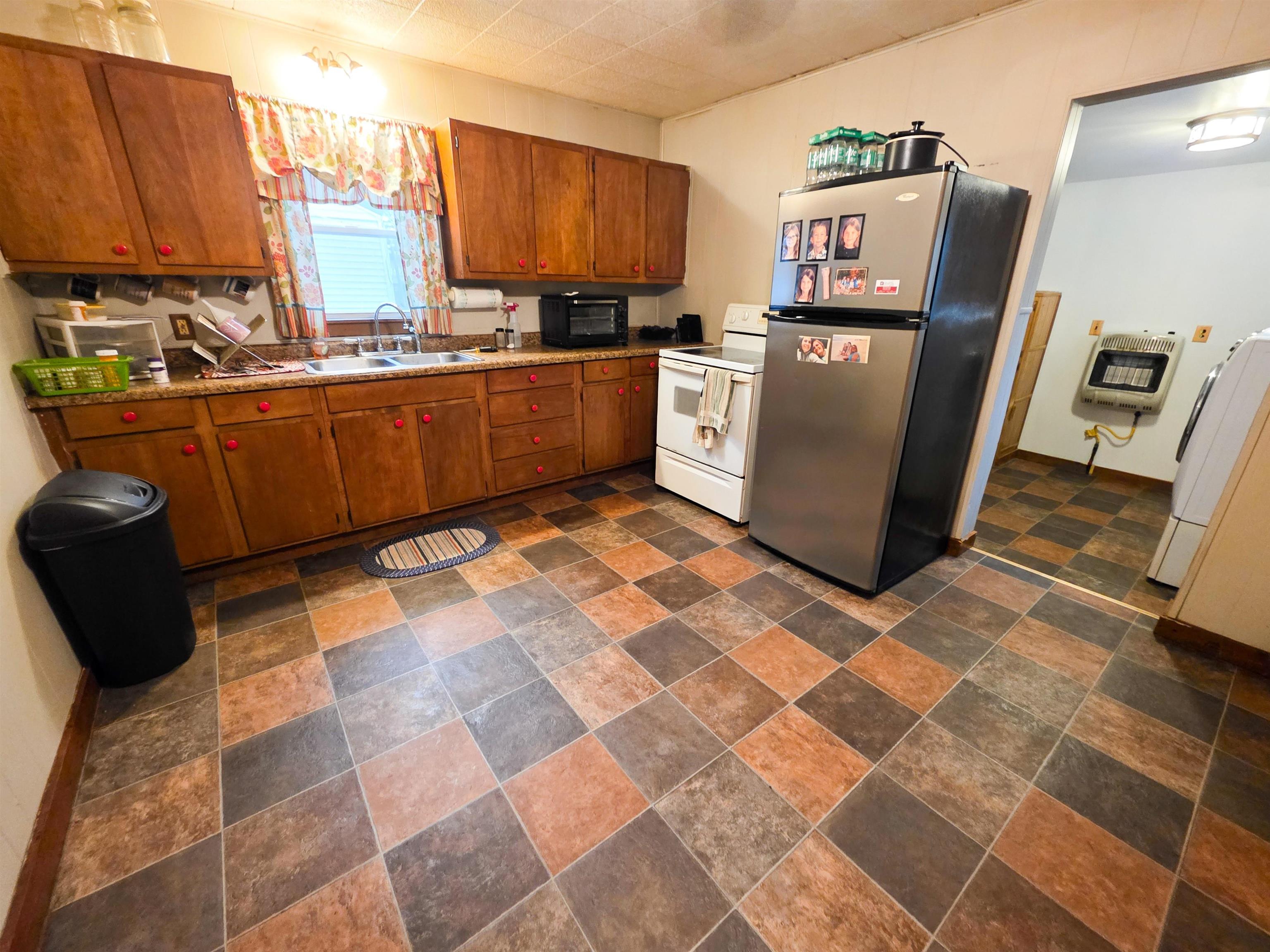 105 Watkins Street Cisne, IL 62823 - Photo 11 of 30 a kitchen with stainless steel appliances a sink a counter top space and a window