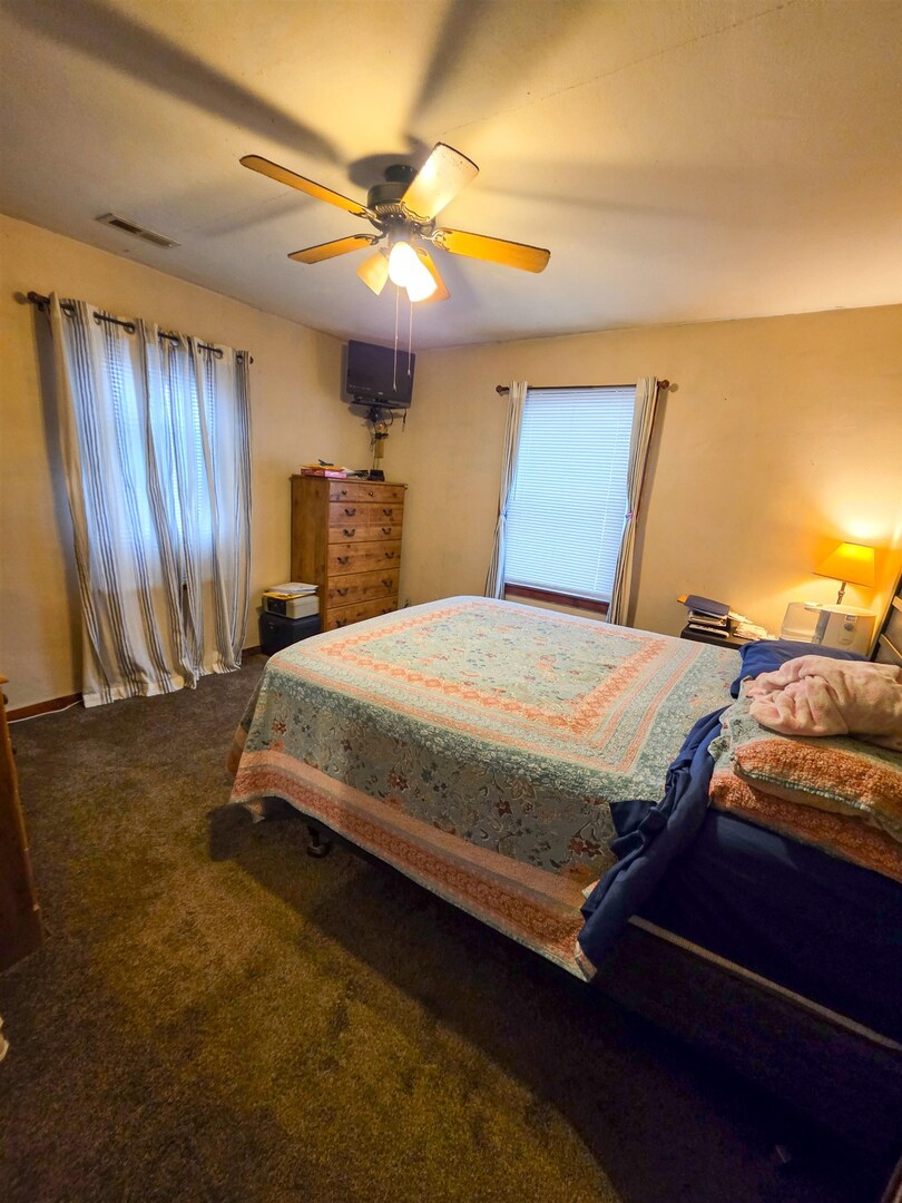 105 Watkins Street Cisne, IL 62823 - Photo 20 of 30 a bedroom with a bed and a chandelier