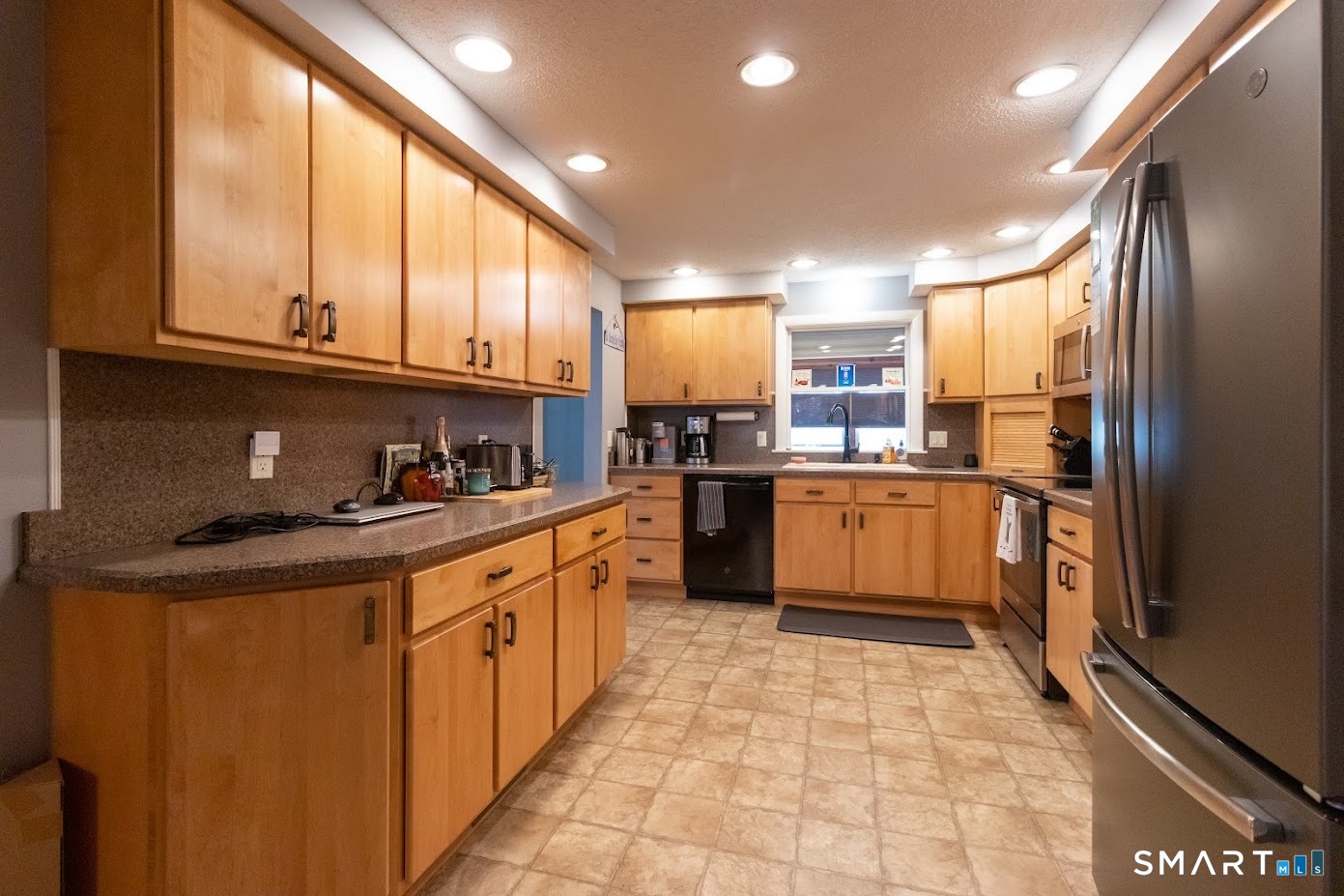 763 North Street Suffield, CT 06078 - Photo 9 of 40 a kitchen with stainless steel appliances granite countertop a sink counter space cabinets and a large window