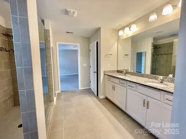 a spacious bathroom with a granite countertop sink mirror and a