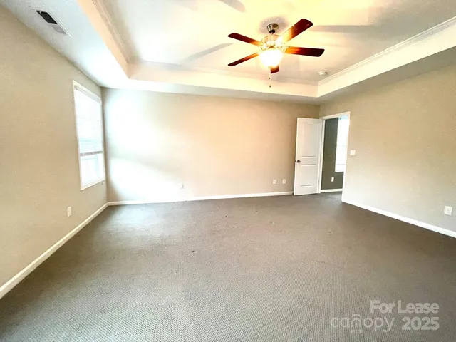 an empty room with a window and a ceiling fan