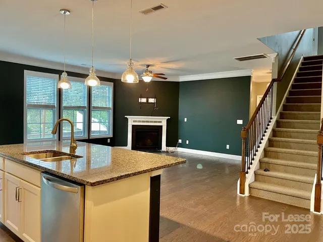 a kitchen with kitchen island a stove and a sink