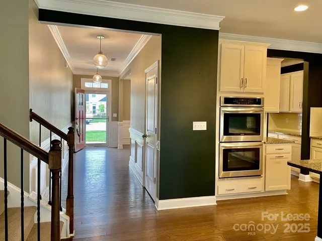 a view of hallway with stairs and wooden floor