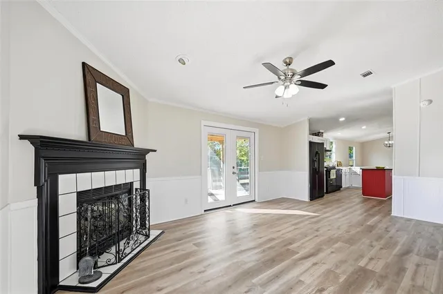 a view of an empty room with window and wooden floor