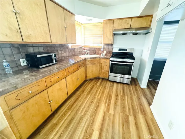 a kitchen with sink a microwave and cabinets