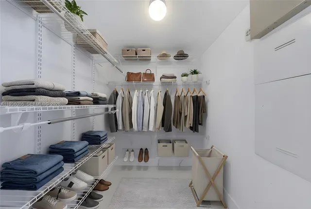 a view of walk in closet with clothes and shoes