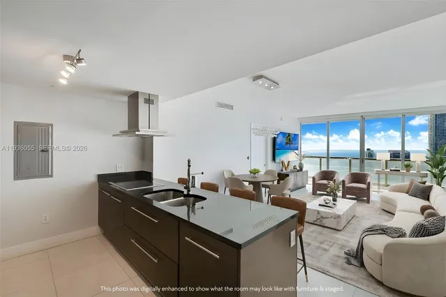 a living room with furniture kitchen view and a large window