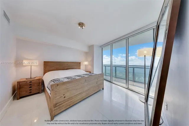 a bedroom with a large bed and a large window