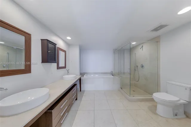 a bathroom with a granite countertop sink a toilet and shower