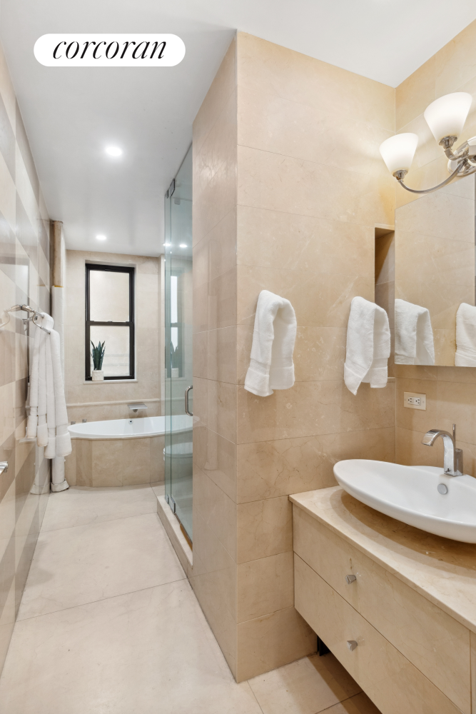 215 West 91st Street, Unit 111 Manhattan, NY 10024 - Photo 10 of 11 a bathroom with a double vanity sink mirror and bathtub