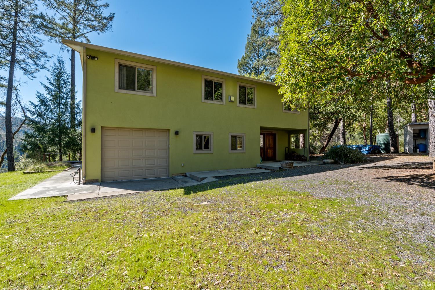 18210 Old Ukiah Pines Road Potter Valley, CA 95469 - Photo 3 of 43 a front view of a house with a yard and garage