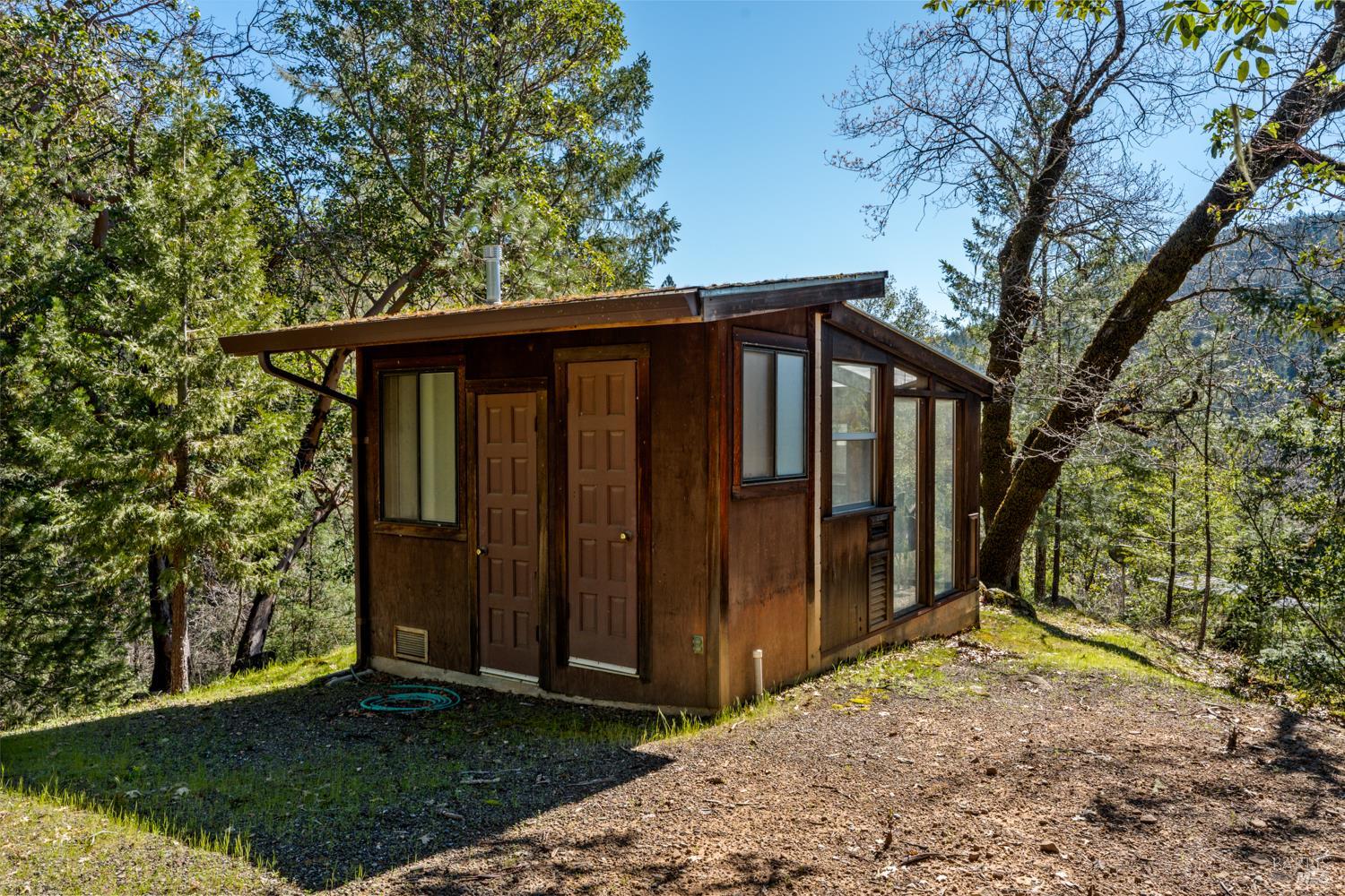 18210 Old Ukiah Pines Road Potter Valley, CA 95469 - Photo 37 of 43 a view of wooden house with a large window and wooden fence