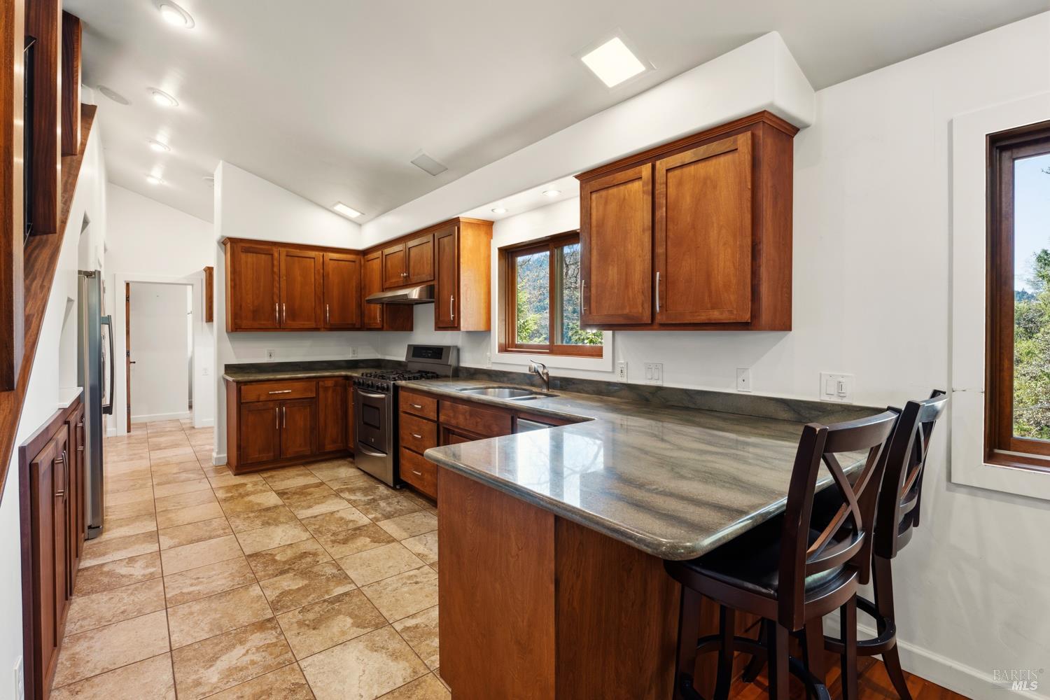 18210 Old Ukiah Pines Road Potter Valley, CA 95469 - Photo 9 of 43 a kitchen with stainless steel appliances wooden cabinets a stove a sink and a microwave