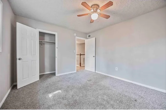 an empty room with a ceiling fan and a window