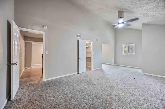 a view of an empty room with a ceiling fan