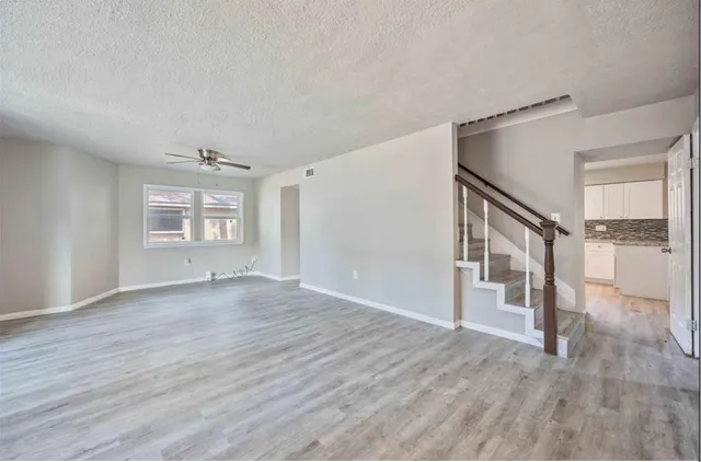 a view of a big room with wooden floor and staircase