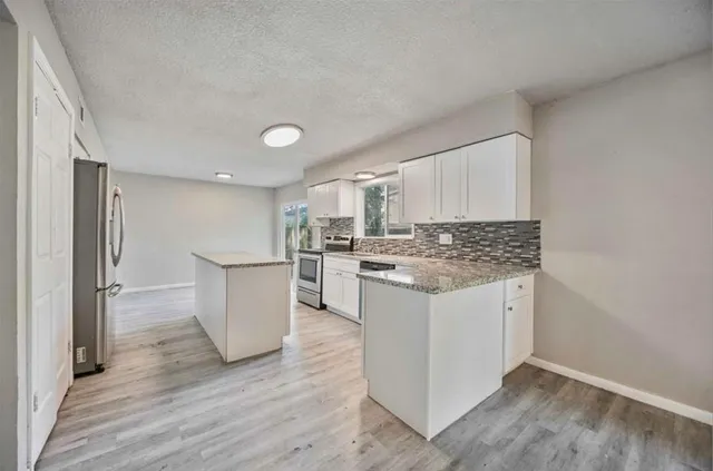 a kitchen with white cabinets and white appliances
