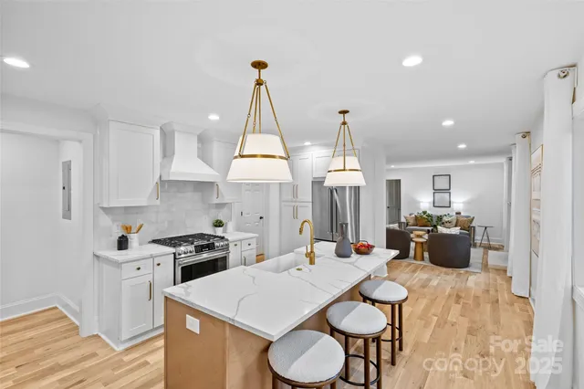 a kitchen with a table chairs stove and white cabinets