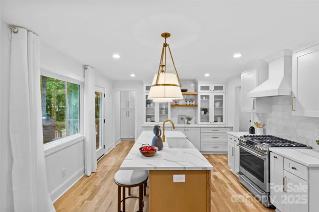 a kitchen with kitchen island a stove a table and chairs in it