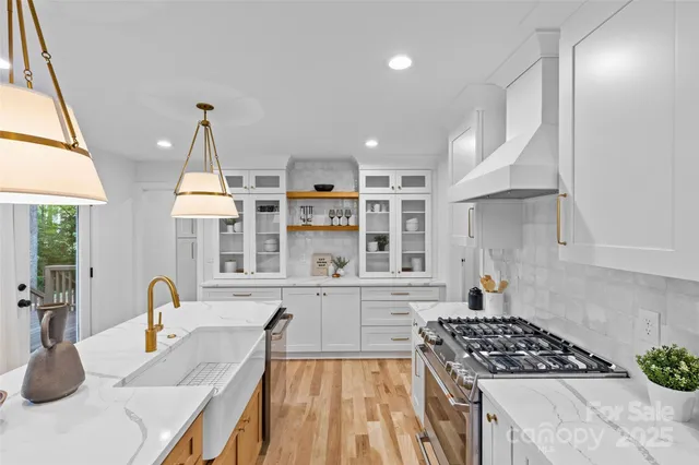 a kitchen with stainless steel appliances granite countertop a stove and a sink