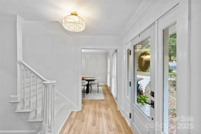 a view of a hallway with wooden floor and dining room
