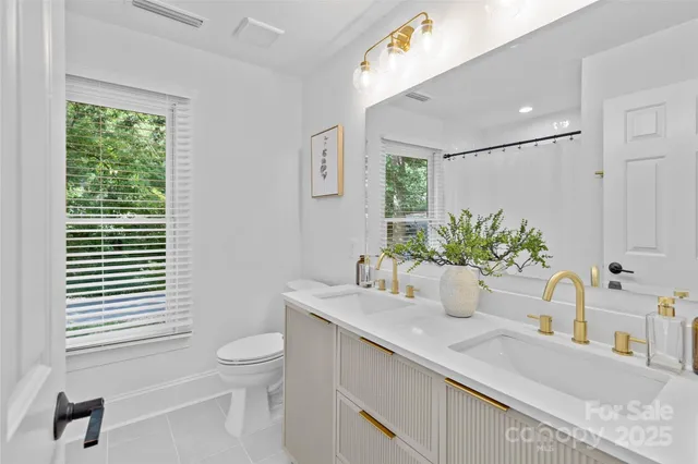a bathroom with a granite countertop sink a toilet and a mirror