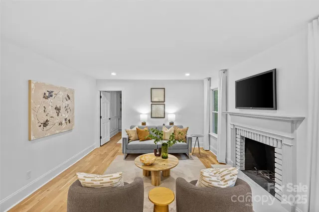 a living room with furniture a flat screen tv and a fireplace