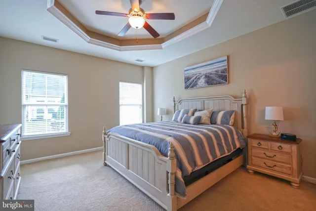 a bedroom with a bed a chandelier and a window