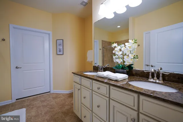 a bathroom with a granite countertop sink and a mirror