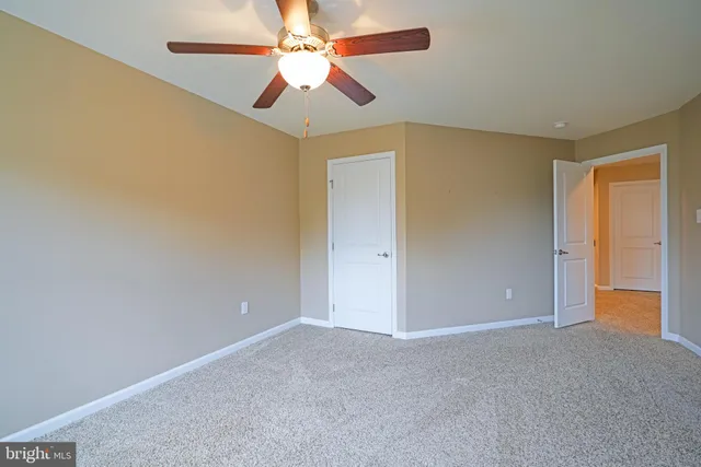 an empty room with a chandelier fan and a ceiling fan