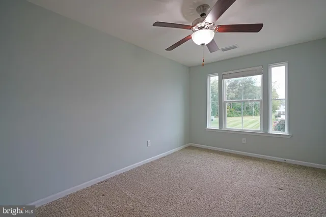 a view of a livingroom with a ceiling fan and window