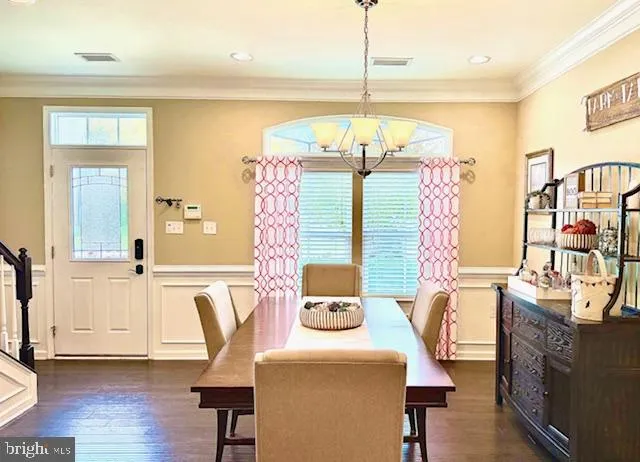 a view of a dining room with furniture a chandelier and wooden floor