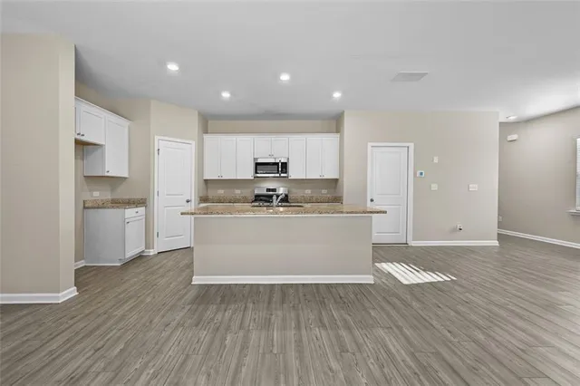 a view of kitchen with granite countertop cabinets and refrigerator