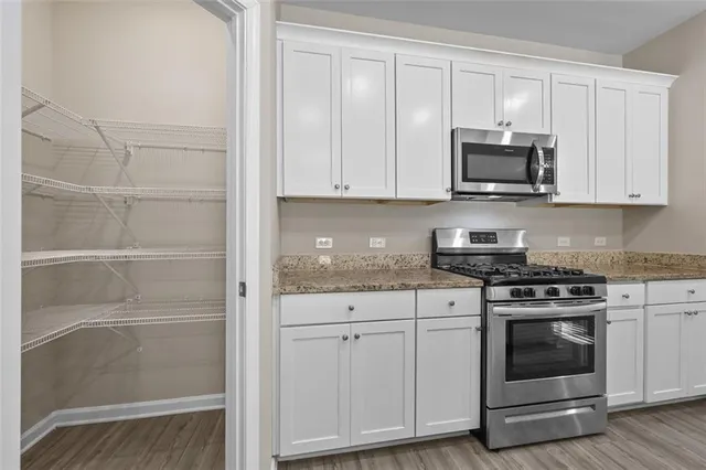 a kitchen with white cabinets and appliances