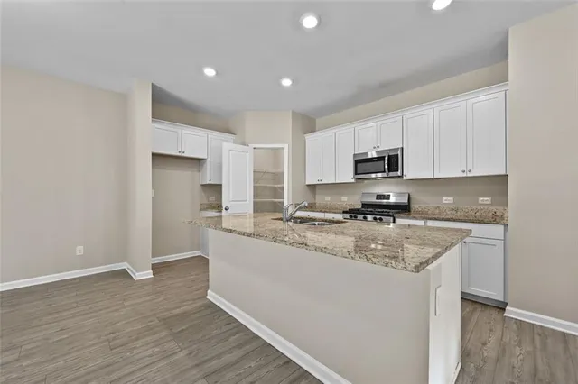 a kitchen with stainless steel appliances granite countertop a stove a sink and a refrigerator