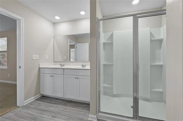 a bathroom with a shower sink and mirror