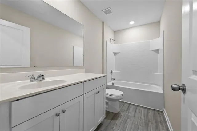 a bathroom with a double vanity sink toilet mirror and shower