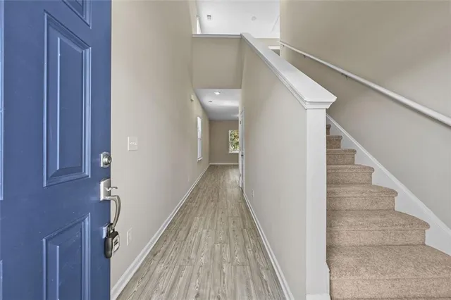 a view of a hallway with wooden floor and staircase