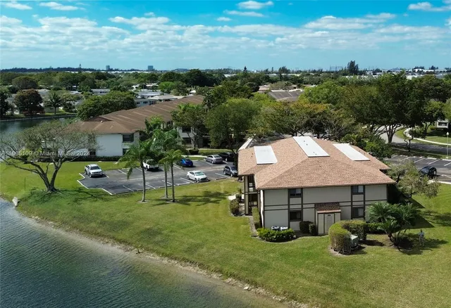 an aerial view of a house with yard and lake view