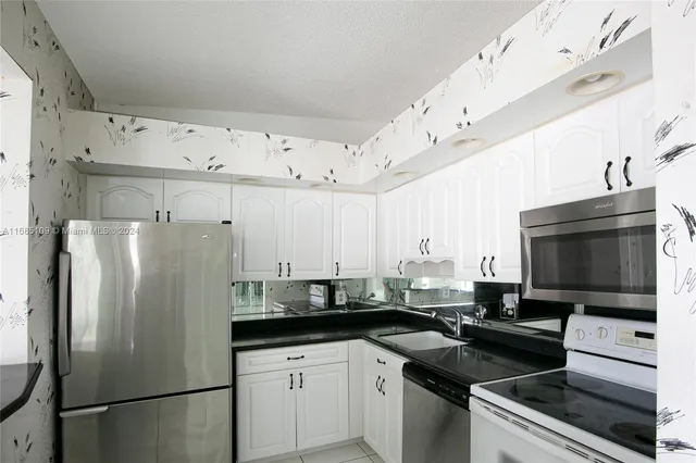a kitchen with a sink stainless steel appliances and white cabinets