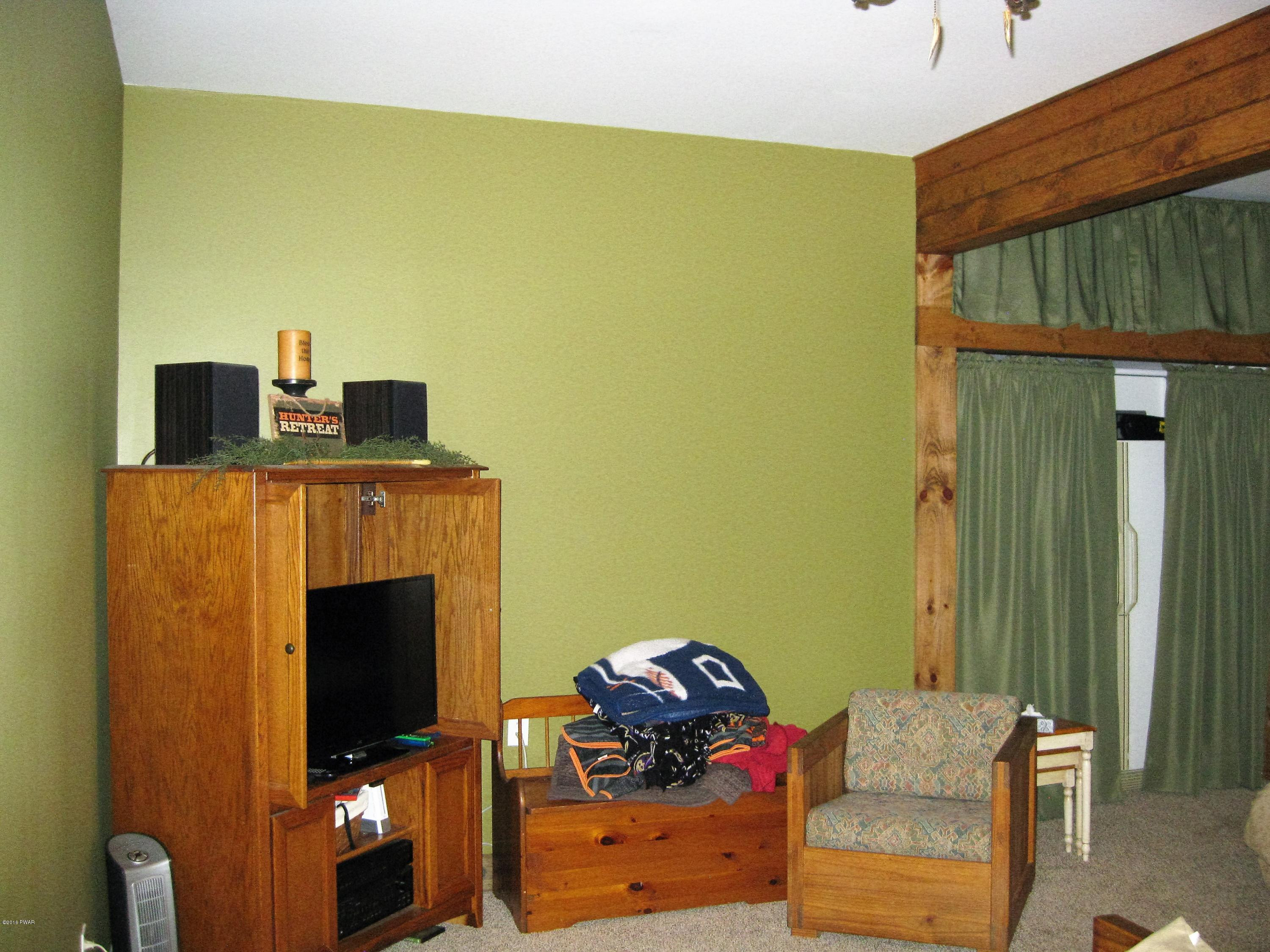 137 Caribou Road Dingmans Ferry, PA 18328 - Photo 23 of 34 a living room with furniture and a fireplace