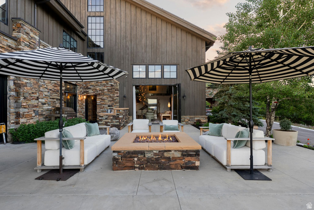 5971 Maple Ridge Trail Oakley, UT 84055 - Photo 11 of 43 Spacious outdoor patio featuring a stone-clad fire pit, concrete surface, and direct access to the interior via large folding doors