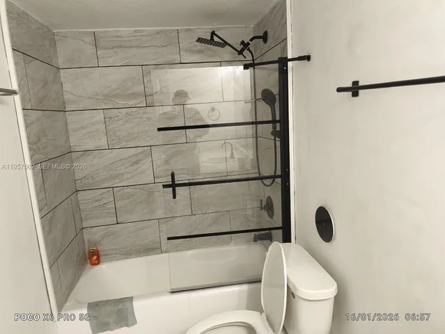 a white toilet sitting next to a bath tub