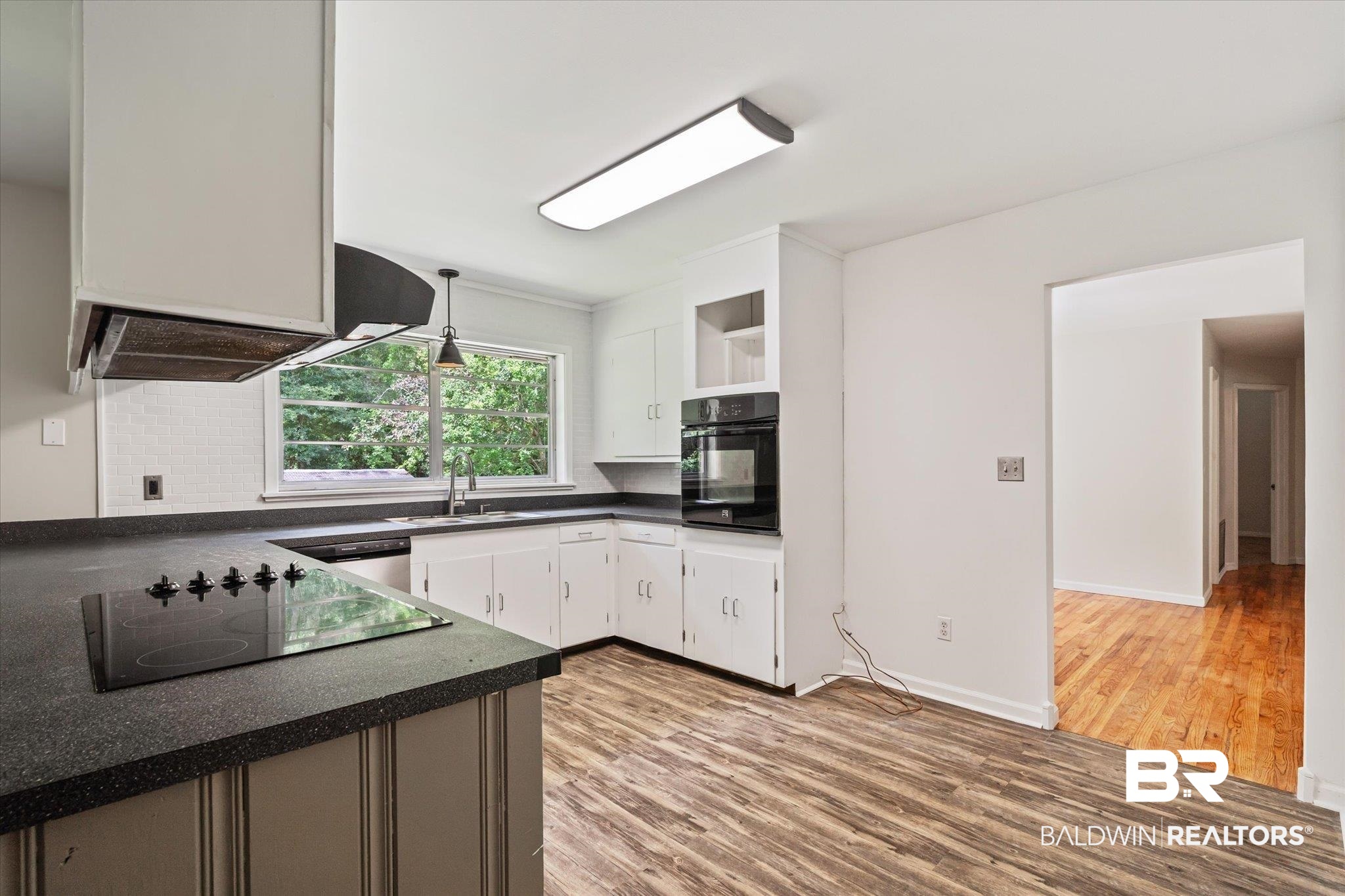 3325 Lacoste Road Mobile, AL 36618 - Photo 5 of 35 Kitchen featuring white cabinetry, black appliances, hanging light fixtures, light hardwood / wood-style flooring, and backsplash