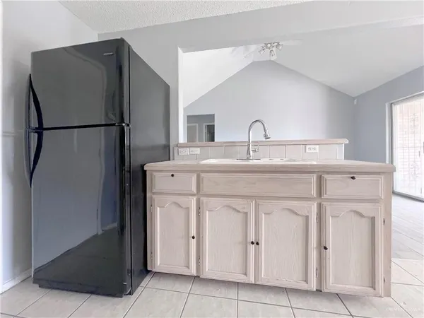 a kitchen with white cabinets and refrigerator